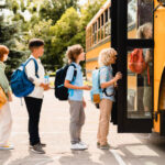 KIDS GETTING ON SCHOOL BUS FOR FIRST DAY OF SCHOOL